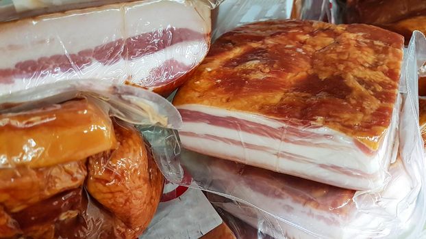 Concept of unhealthy food - processed meat packed in a plastic for sale in a large supermarket in close-up