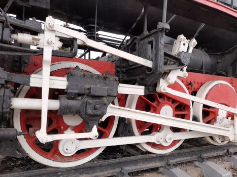 Wheels of an old steam locomotive on rails close-up.