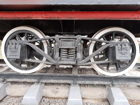 Wheels of an old steam locomotive on rails close-up.