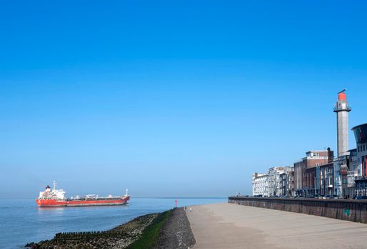 vlissingen, netherlands, 31 march 2021: ship on westerschelde near vlissingen boulevard sets out for north sea on sunny spring day in dutch province of zeeland