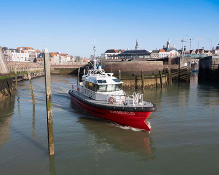 vlissingen, netherlands, 31 march 2021: pilot boat leaves vlissingen harbor on sunny day in spring