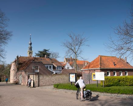 Veere, Netherlands, 31 march 2021: visitors by bicycle in old dutch town of Veere in dutch province of zeeland in the netherlands on sunny day early spring