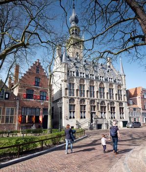 Veere, Netherlands, 31 march 2021: visitors on market square in old dutch town of Veere in dutch province of zeeland in the netherlands on sunny day early spring