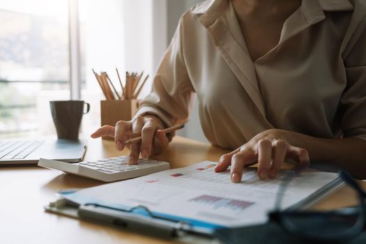 Close up Business woman or accountant using calculator with computer laptop, Business accounting, budget and loan paper at home.