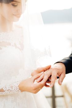 the bride puts the ring on the groom's finger during the wedding ceremony. High quality photo