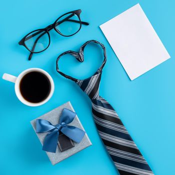 Design concept top view of Father's day gift idea with greeting white blank mockup on blue table background.