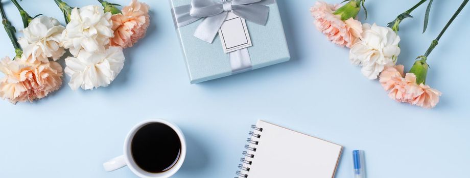 Design concpet of Mother's Day greeting with carnation flower, holiday gift idea and notebook diary on mother's desk background.