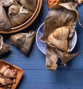 Zongzi rice dumpling with ingredients top view for Chinese traditional Dragon Boat Festival (Duanwu Festival) over blue wooden table background.