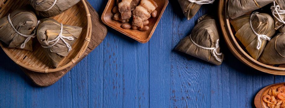 Zongzi rice dumpling with ingredients top view for Chinese traditional Dragon Boat Festival (Duanwu Festival) over blue wooden table background.