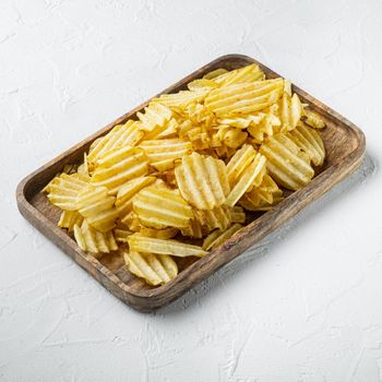 Delicious crispy potato chips set, on white stone surface