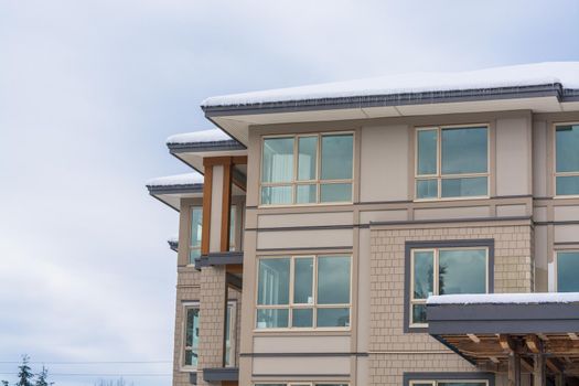 Four corners of brand new low rise condo building on winter cloudy day in Vancouver, BC