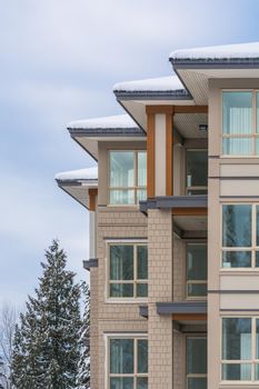 Four corners of new low rise condo building on winter cloudy day in Vancouver, BC