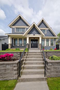 Concrete steps leading to residential house entrance over the front yard.  Luxury family house built on land terrace