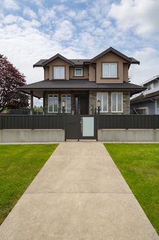 Brand new luxury residential house for sale. Big family house with concrete pathway and metal  fence in front
