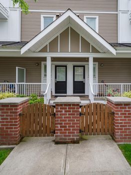 Entrance doors of residential townhouses with strollers under the porch. Attached residential townhomes entrance