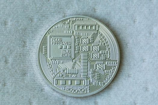 Revers of bitcoin metal coin on blue fiber texture background