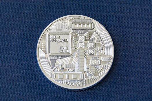 Revers of bitcoin metal coin on blue fiber texture background