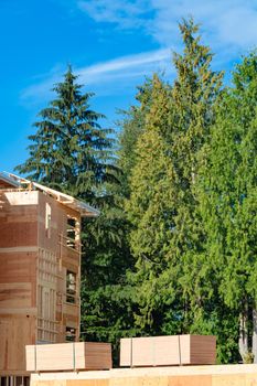 Apartment building under construction with two trunks of timber stored beside