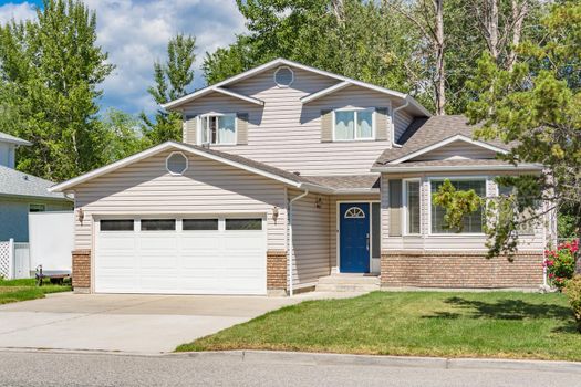 A perfect neighbourhood. Family house with landscaped front yard on sunny day in British Columbia