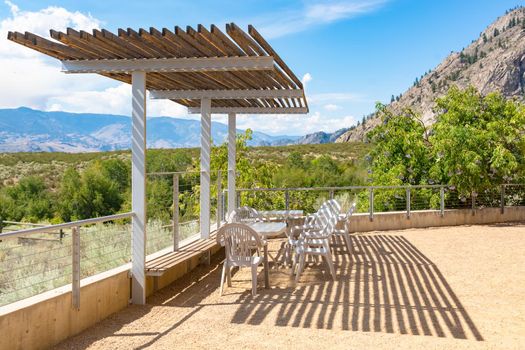 Recreational area with chairs and tables in shadow of the canopy with mounain view background