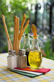 Italian serving. Table set of olive oil, bread sticks, salt, pepper. Vertical