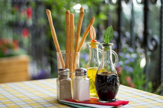 Italian serving. Table set of olive oil, bread sticks, salt, pepper, soy sauce, vinegar