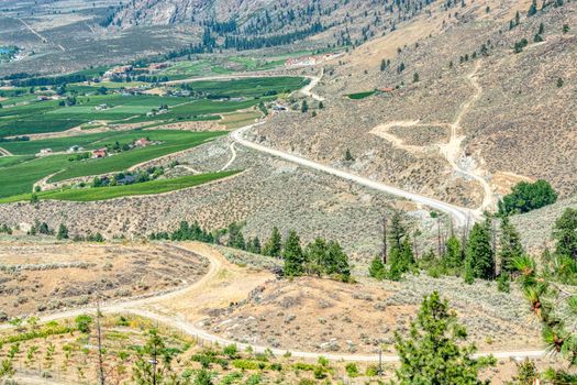 Landscape with orchard farms and residnetial houses at Okanagan lake on hot summer day