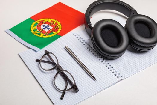 Learn foreign languages in Portugal with audio recordings and headphones. Notepad, glasses, pen.