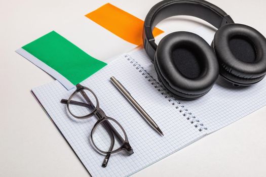 Learn foreign languages in Ireland with audio recordings and headphones. Notepad, glasses, pen.