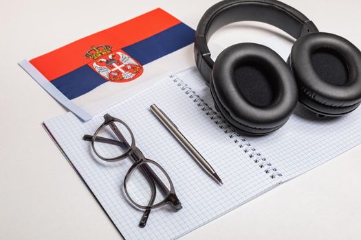 Learning foreign languages in Serbia with audio recordings and headphones. Notepad, glasses, pen.