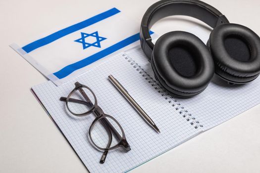 Learning foreign languages in Israel with audio recordings and headphones. Notepad, glasses, pen.