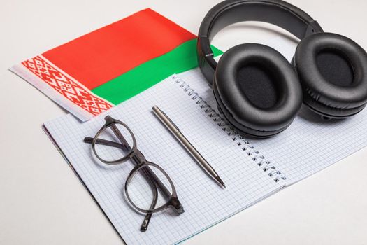 Learning foreign languages in Belarus with the help of audio recordings and headphones. Notepad, glasses, pen.