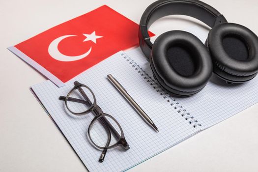 Learning foreign languages in Turkey with audio recordings and headphones. Notepad, glasses, pen.