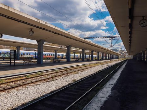 Empty coaches at a rail track platform without passengers.