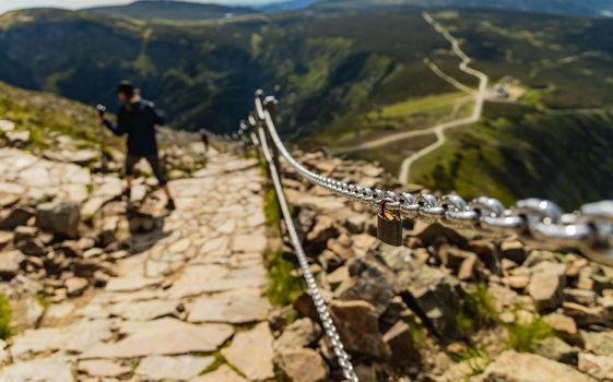 Small padlock hanging on chain next to mountain trail in Giant Mountains