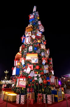 DUBAI, UAE - DECEMBER 16 2020 . Beautifully decorated christmas tree with gifts and lights captured at the park entertainment in the at The Global Village , Dubai,UAE.