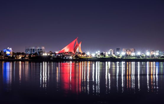 DEC 29TH 2020 ,DUBAI,UAE. Panoramic view of the distinctively sail-shaped illuminated clubhouse of Dubai Creek Golf and Yacht Club from across the Dubai Creek park, Deira Dubai UAE