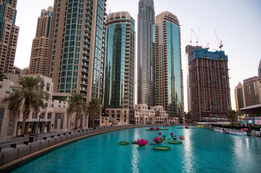 JAN 7th 2021, DUBAI, UAE. TOURISTS RIDING THE BOATS IN THE BEAUTIFUL LOTUS FLOWER POOL AT THE RECREATIONAL BOULEVARD AREA OF THE BURJ PARK, DUBAI,UAE.