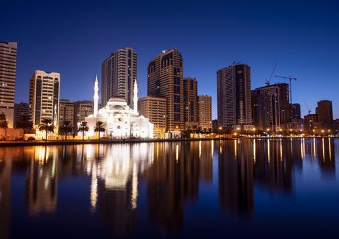 Jan 8th 2021, Sharjah, UAE. Panoramic view of the beautifully illuminated Al Noor mosque during the early sunrise hours showing reflections in water captured from the Al Noor island Sharjah, UAE.