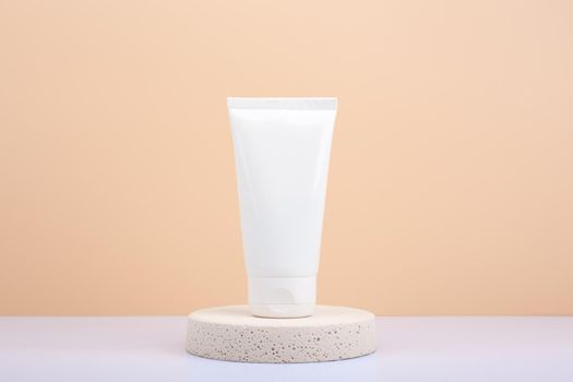 Hand cream, lotion or scrub on round beige podium against beige background with copy space. Concept of beauty products for skin on hands and manicure