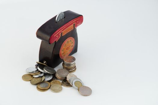 A money box with coins is isolated on a white background with a place for an inscription. High quality photo