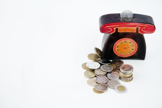 A money box with coins is isolated on a white background with a place for an inscription. High quality photo