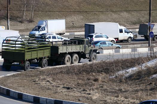 Passenger transport and a military vehicle on the city road. High quality photo