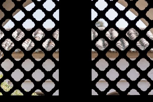 Detail of an old wood latice in a window on a sunny day