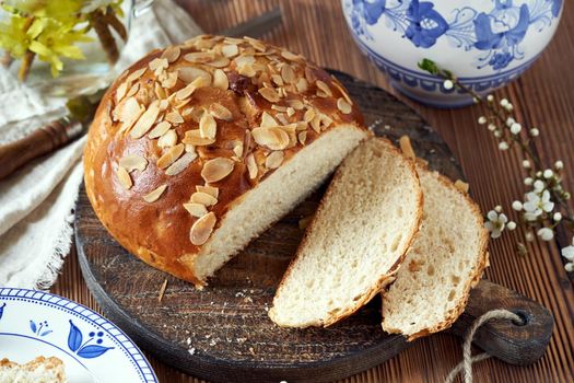 Mazanec, traditional Czech sweet Easter pastry, similar to hot cross bun, on a table with a blue jug and plates