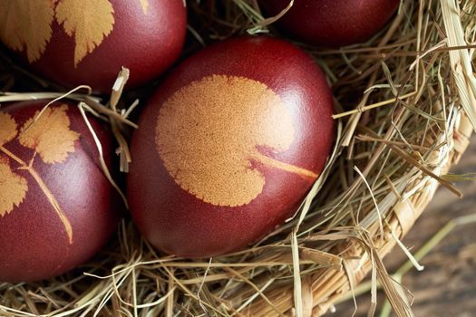 Closeup of Easter eggs dyed with onion peels with a pattern of plants in a basket