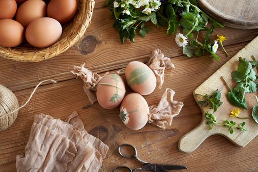 Preparing Easter eggs for dyeing with onion peels - attaching fresh leaves to them with pieces of old nylon stockings