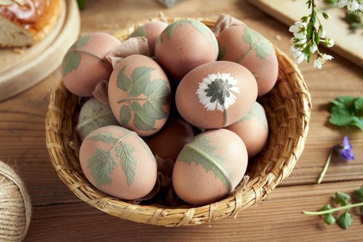 Preparation of Easter eggs for dying with onion peels, decorated with a pattern of leaves