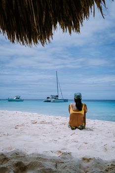 Small Curacao Island famous for day trips and snorkeling tours on white beaches blue clear ocean, Curacao Island in the Caribbean sea. a couple of men and woman on the beach during a vacation holiday