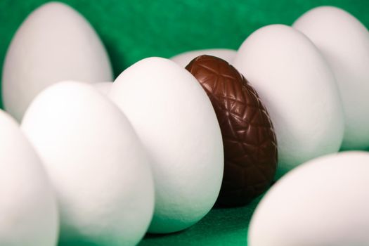 Brown chocolate Easter egg with plain white candy coated eggs